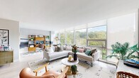 Located in Pittsburgh's vibrant East End, this thoughtfully designed 2-bedroom, 2-bathroom residence offers a seamless blend of modern architecture and mid-century style. The open-plan living and dining area is anchored by expansive floor-to-ceiling windows that flood the space with natural light and frame stunning treetop views, creating an airy, gallery-like atmosphere with light hardwood flooring underfoot.

The galley kitchen is well-appointed with rich dark wood cabinetry, granite countertops, a herringbone tile backsplash, and stainless steel appliances — both functional and visually striking. The dining area features an artistic accent wall, adding character and depth to the entertaining space.

The generously sized primary bedroom is a serene retreat, offering large windows with lush green views, plush carpeting, and ample built-in closet storage accented by bold botanical wallpaper. The second bedroom also enjoys panoramic window views, making it equally suited as a guest room or home office. Both bathrooms are finished with granite-topped wood vanities and clean, contemporary fixtures.

Additional highlights include a dedicated laundry area, five closets for exceptional storage, and a welcoming entrance foyer. With five closets throughout and a well-connected layout, this residence offers both comfort and practicality in equal measure.
