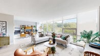 Located in Pittsburgh's vibrant East End, this thoughtfully designed 2-bedroom, 2-bathroom residence offers a seamless blend of modern architecture and mid-century style. The open-plan living and dining area is anchored by expansive floor-to-ceiling windows that flood the space with natural light and frame stunning treetop views, creating an airy, gallery-like atmosphere with light hardwood flooring underfoot.

The galley kitchen is well-appointed with rich dark wood cabinetry, granite countertops, a herringbone tile backsplash, and stainless steel appliances — both functional and visually striking. The dining area features an artistic accent wall, adding character and depth to the entertaining space.

The generously sized primary bedroom is a serene retreat, offering large windows with lush green views, plush carpeting, and ample built-in closet storage accented by bold botanical wallpaper. The second bedroom also enjoys panoramic window views, making it equally suited as a guest room or home office. Both bathrooms are finished with granite-topped wood vanities and clean, contemporary fixtures.

Additional highlights include a dedicated laundry area, five closets for exceptional storage, and a welcoming entrance foyer. With five closets throughout and a well-connected layout, this residence offers both comfort and practicality in equal measure.