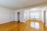 Located at 1640 NE Irving St in Portland, Oregon, this one-bedroom, one-bathroom unit offers a well-organized layout across a single floor. Gleaming hardwood floors run throughout the living areas and bedroom, reflecting natural light and lending a warm, cohesive character to the space.

The living room is generously sized, featuring a large multi-pane window fitted with blinds and a baseboard radiator beneath it, providing both natural light and efficient heating. Textured ceilings add a classic touch to the bright, white-walled interior.

The bedroom is a comfortable and spacious room with two windows that allow ample natural light from multiple angles. It includes a built-in closet and connects seamlessly to the rest of the unit via a hallway that also features closet storage.

The kitchen is a galley-style space with abundant white cabinetry on both sides, ample counter space, a window overlooking greenery, and durable speckled tile flooring. It is equipped with a refrigerator, dishwasher, and a double sink.

The bathroom features a full-size soaking tub with a showerhead and floor-to-ceiling cream tile surround, offering a clean and functional design. Throughout the unit, the consistent use of light tones and natural materials creates a calm, inviting atmosphere ideal for everyday living.