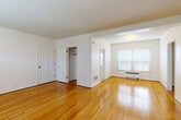 Located at 1640 NE Irving St in Portland, Oregon, this one-bedroom, one-bathroom unit offers a well-organized layout across a single floor. Gleaming hardwood floors run throughout the living areas and bedroom, reflecting natural light and lending a warm, cohesive character to the space.

The living room is generously sized, featuring a large multi-pane window fitted with blinds and a baseboard radiator beneath it, providing both natural light and efficient heating. Textured ceilings add a classic touch to the bright, white-walled interior.

The bedroom is a comfortable and spacious room with two windows that allow ample natural light from multiple angles. It includes a built-in closet and connects seamlessly to the rest of the unit via a hallway that also features closet storage.

The kitchen is a galley-style space with abundant white cabinetry on both sides, ample counter space, a window overlooking greenery, and durable speckled tile flooring. It is equipped with a refrigerator, dishwasher, and a double sink.

The bathroom features a full-size soaking tub with a showerhead and floor-to-ceiling cream tile surround, offering a clean and functional design. Throughout the unit, the consistent use of light tones and natural materials creates a calm, inviting atmosphere ideal for everyday living.