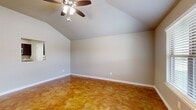 This well-appointed single-story home offers three bedrooms, two bathrooms, and a thoughtfully designed layout across a comfortable footprint. A standout architectural feature throughout the home is the rich, amber-toned stained concrete flooring, which lends a warm and distinctive character to every room.

The open living area impresses with soaring vaulted ceilings and a ceiling fan with light fixture, creating an airy, spacious atmosphere. A pass-through window connects the living space directly to the kitchen, promoting an open and connected feel. The kitchen is equipped with dark espresso cabinetry, granite countertops, a double stainless steel sink, a dishwasher, and a range — all complemented by the same striking stained concrete floors.

The primary bedroom features vaulted ceilings and a ceiling fan, adding to the sense of volume and comfort. Each bedroom includes closet storage with built-in shelving and hanging rods. The bathrooms are clean and functional, with one featuring a full tub-shower combination with white tile surround.

A central hallway connects the bedrooms and bathrooms efficiently. The attached garage provides additional storage and parking space, finished with a standard roll-up door and automated opener. Throughout the home, neutral wall tones and white trim create a clean, cohesive aesthetic.