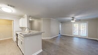 Located at 22 Forest Cir in Newnan, GA, this well-appointed 2-bedroom, 2-bathroom residence offers a comfortable and functional single-floor layout. The open-concept kitchen is a standout feature, showcasing granite countertops, white shaker cabinetry, black appliances including a refrigerator, electric range, and microwave, and a peninsula with bar seating that connects seamlessly to the living area. Light wood-look LVP flooring runs throughout the home, complemented by crown molding and neutral-toned walls that create a clean, cohesive aesthetic.

The living room is bright and inviting, featuring a ceiling fan, crown molding, and French doors that allow natural light to flow into the space. Both bedrooms are generously sized, each equipped with ceiling fans and windows that bring in natural light. The spacious primary bedroom offers ample room and connects to its own bathroom, while the second bedroom is equally comfortable and versatile.

Both bathrooms feature tub-shower combinations and wood-look flooring, with the primary bath offering a vanity with white cabinetry. A dedicated laundry room houses a full-size washer and dryer, adding everyday convenience. A hallway and closet complete the thoughtfully designed floor plan.