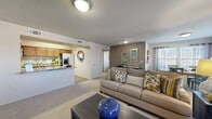 This single-floor residence offers a thoughtfully designed layout across two bedrooms, three bathrooms, a living room, dining room, kitchen, and two closets. The open-concept living area is anchored by a dark-mantled fireplace framed by large windows that invite generous natural light, and is finished with soft wall-to-wall carpeting. The living space flows seamlessly into a dedicated dining area, which features a bright window bay ideal for everyday meals or entertaining. The kitchen is well-equipped with warm honey-toned wood cabinetry, stone-patterned countertops, stainless steel appliances including a side-by-side refrigerator with ice dispenser, and durable tile flooring. The primary bedroom is a comfortable retreat with a ceiling fan, dual windows with blinds, and plush carpeting. Each of the three bathrooms is finished consistently with tile flooring, wood vanity cabinetry, stone-look countertops, and tub-shower combinations with tiled accents. Two dedicated closets provide practical storage throughout the residence. The neutral color palette, consistent finishes, and functional floor plan make this a well-rounded and comfortable living space.