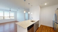 Located at 2500 Summer Lee Dr in Rockwall, Texas, this single-floor residence offers a clean, modern aesthetic throughout. The open-concept living and kitchen area is anchored by a large island with granite countertops, an undermount sink, and elegant pendant lighting overhead. The kitchen is equipped with stainless steel appliances, including a refrigerator, dishwasher, and microwave, complemented by sleek cabinetry and warm hardwood-style flooring that extends through the main living areas. The spacious living area provides ample room for a variety of furniture arrangements and features crisp white walls that enhance the bright, airy atmosphere.

The bedroom offers plush carpeting, a ceiling fan, and a window with outdoor views, creating a comfortable and tranquil retreat. The primary bathroom is well-appointed with a double-sink granite vanity, large mirror with stylish bar lighting, a soaking tub, and a separate glass-enclosed shower. A walk-in closet with shelving is conveniently accessible directly from the bathroom. Throughout the unit, consistent use of hardwood-style flooring, white walls, and modern fixtures creates a cohesive and contemporary feel. The thoughtful layout and quality finishes make this Rockwall residence a polished and functional living space.