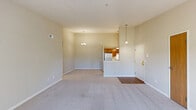 This well-appointed 2-bedroom, 2-bathroom residence at 4502 Grand Lake Dr in Brunswick, Ohio offers a comfortable and functional single-floor layout. The open-concept living and dining area is generously sized, featuring soft neutral-toned carpet, a textured ceiling, and a large sliding glass door dressed with vertical blinds that floods the space with natural light and provides direct access to an outdoor patio with pleasant views. A chandelier-style light fixture marks the transition to the dining area, which flows seamlessly into the kitchen, outfitted with warm wood-toned cabinetry and light countertops. The primary bedroom is notably spacious, complete with a ceiling fan, plush carpeting, and access to a private bathroom featuring a stand-up shower with frosted glass doors, a wood-vanity, and tile-style flooring. The second bedroom also features a ceiling fan and a bright window overlooking greenery, offering a comfortable and airy feel. Dual sliding wood-paneled closet doors provide ample storage in the second bedroom. The main bathroom includes a full tub-shower combo, a wood vanity, and matching tile-style flooring. A hallway with additional closet space and a kitchen utility area with wood-tone cabinetry round out this practical and inviting home.