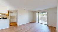 This single-floor, 2-bedroom, 2-bathroom residence offers a practical and comfortable layout with a clean, neutral aesthetic throughout. Warm hardwood-style flooring runs continuously across the living spaces, complementing the crisp white walls and textured ceilings that define each room.

The open living area is bright and inviting, featuring a ceiling fan, a sliding glass door that leads to an outdoor patio, and abundant natural light. A pass-through window connects the living space to the galley-style kitchen, which is efficiently designed with light wood cabinetry, white countertops, a stainless steel gas range, a stainless steel refrigerator, and a double-basin sink — providing ample storage and workspace for everyday cooking.

Both bedrooms are comfortably sized with large windows that bring in natural light. The primary bedroom features a spacious built-in closet with sliding doors and integrated shelving, offering generous storage. Each bathroom is consistently appointed with a full tub-shower combination, wood-toned vanity cabinetry, white countertops, and hardwood-style flooring, maintaining a cohesive look throughout.

The overall ambiance of the space is clean, bright, and functional, with a neutral color palette that creates a versatile and move-in-ready environment.
