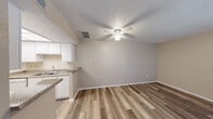 Located at 2038 W Stassney Ln in Austin, TX 78745, this one-bedroom, one-bathroom unit offers a well-organized single-floor layout designed for efficient, comfortable living. The open-concept living area flows seamlessly from the kitchen, featuring wood-look plank flooring, neutral warm-toned walls, a textured ceiling, and a ceiling fan with integrated lighting. A sliding glass door with vertical blinds connects the living space to a private outdoor balcony, bringing in natural light and extending the sense of space.

The galley-style kitchen is well-appointed with white cabinetry, granite-look countertops, a stainless steel sink, a white electric range, a refrigerator, and overhead fluorescent lighting — providing ample storage and functional workspace along both sides.

The bedroom is a comfortable, quiet retreat with wood-look flooring, a ceiling fan, a window with blinds offering natural light, and a mirrored sliding-door closet that adds depth and storage.

The bathroom includes a vanity with granite-look countertops, white cabinetry, a large mirror, and a full tub-shower combo, finished in clean, neutral tones throughout. The unit's cohesive design and practical layout make it an efficient and inviting living space.
