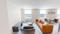Located at 2024 Jane St in Pittsburgh's South Side neighborhood, this one-bedroom, one-bathroom unit offers a thoughtfully designed, modern living space across a single floor. Light wood flooring runs throughout, lending warmth and continuity to the open layout.

The living room is bright and airy, featuring a large window with city views, recessed lighting, and clean white walls that create a welcoming, minimalist atmosphere. The kitchen is well-appointed with light wood cabinetry, stainless steel appliances including a range, microwave, and dishwasher, and a functional galley-style layout. A dining area adjacent to the kitchen benefits from natural light through a side window.

The bedroom is a calm, comfortable retreat with two windows that allow ample natural light and offer exterior views. A double-door closet provides generous storage, and the light flooring continues seamlessly from the rest of the unit.

The bathroom is finished in a contemporary style, featuring a wood-toned vanity with an illuminated mirror, light wood-look flooring, and a walk-in shower enclosed by sleek black-framed glass doors. The overall design of the unit is clean, modern, and cohesive, making efficient use of its compact footprint while maintaining a comfortable and stylish living environment.
