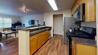 Located at 500 Bedford Street in Stamford, Connecticut, this one-bedroom, one-bathroom residence offers a well-designed single-floor layout with a cohesive and functional flow throughout. Warm hardwood flooring extends across the main living areas, creating a consistent and inviting aesthetic.

The kitchen is a standout feature, equipped with stainless steel appliances including a refrigerator, gas range, and over-the-range microwave. Rich dark granite countertops complement the honey-toned wood cabinetry, and a peninsula with bar seating connects the kitchen to the living area, making it ideal for casual dining and entertaining.

The living room is generously sized and filled with natural light from large windows with blinds and a glass door that opens to the outside. The space comfortably accommodates both a seating area and a dedicated workspace, offering versatility for everyday living.

The bedroom is a quiet, carpeted retreat featuring a sizable window that brings in natural light. Ample storage is provided through a closet and dresser space. The bathroom includes hardwood flooring, a wide vanity with warm wood cabinetry, an oversized mirror with bright overhead lighting, and a shower-tub combination. The overall ambiance of the residence is warm, practical, and well-suited for comfortable urban living in downtown Stamford.