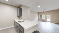 This 660 square foot apartment in Towson, MD offers a thoughtfully designed living space with a blend of modern amenities and practical features. The open-concept layout seamlessly integrates the living room and kitchen, creating a spacious feel. The kitchen boasts sleek gray cabinetry, stainless steel appliances, and a convenient breakfast bar, perfect for casual dining or entertaining.

The generously sized bedroom, measuring 160 square feet, provides ample space for a comfortable retreat. Large windows throughout the apartment allow natural light to flood in, enhancing the airy atmosphere. The bathroom features a modern design with a tub-shower combination and clean white tilework.

Wood-style flooring runs consistently throughout the apartment, adding warmth and easy maintenance. The neutral color palette of the walls provides a versatile backdrop for various decor styles. A ceiling fan in the main living area offers additional comfort and air circulation.

The apartment's single floor layout and thoughtful design make it an ideal choice for those seeking a low-maintenance yet stylish living environment. With its prime location in Towson and contemporary features, this apartment presents an attractive option for urban dwellers looking for comfort and convenience.