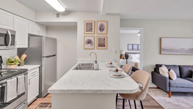 Our kitchens feature a seamless breakfast bar, with stunning white Carrara countertops, creating a bridge between the kitchen masterpiece and the inviting living space. - River Bluff of Lexington