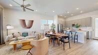 This two-story home is thoughtfully designed across two floors, offering three bedrooms and three bathrooms within a well-utilized layout. The main floor hosts an open-concept living, dining, and kitchen area that flows seamlessly together. Light wood-look flooring runs throughout, complemented by recessed lighting and neutral white walls that create a bright, welcoming atmosphere. A ceiling fan anchors the living room, which features large windows dressed with blinds and floor-length drapes, allowing ample natural light while maintaining privacy.

The kitchen is outfitted with gray shaker-style cabinetry, white quartz countertops, a subway tile backsplash, and stainless steel appliances, including a refrigerator, range, and built-in microwave. A half bathroom is conveniently located on the main floor.

Upstairs, the primary bedroom includes a walk-in closet and is served by a well-appointed full bathroom featuring gray cabinetry with granite countertops, a glass-enclosed walk-in shower, and tile flooring. Two additional carpeted bedrooms and a third full bathroom complete the upper level. The home also incorporates a smart home system.
