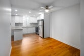 This 2-bedroom, single-floor unit at 165 La Rose Ave in Toronto's M9P neighbourhood offers a practical and well-finished layout. The open-concept kitchen is a standout feature, equipped with stainless steel appliances including a refrigerator, electric range, and built-in microwave, complemented by white shaker-style cabinetry, a tile backsplash, and a neutral countertop peninsula that extends toward the living area. Recessed lighting and a ceiling fan add functionality to this shared space.

Warm hardwood-style flooring runs throughout the unit, creating a cohesive feel across all rooms. The spacious primary bedroom features large windows that frame outdoor tree views, flooding the room with natural light, and includes a sliding-door closet with built-in shelving and hanging rods. The second bedroom also benefits from a window with outdoor views. A full bathroom features a double-sink vanity with ample cabinetry and an illuminated mirror. A central hallway connects all rooms efficiently, contributing to the unit's clean, functional flow.