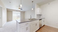 Located on E Gemstone Ln in Wichita, Kansas, this single-story, 2-bedroom, 2-bathroom unit offers a thoughtfully designed layout with modern finishes throughout. The open-concept kitchen flows directly into the living area, creating a cohesive and functional common space. The kitchen features white shaker-style cabinetry, gray countertops, a white subway tile backsplash, stainless steel appliances including a gas range, microwave, dishwasher, and refrigerator, and wood-look flooring. A peninsula with a double-basin sink and pendant lighting serves as a natural divide between the kitchen and the carpeted living room, which receives natural light through a sliding glass door fitted with vertical blinds.

The two bedrooms are carpeted and include ceiling fans. The spacious primary bedroom benefits from natural light through a window and connects to a walk-in closet equipped with wire shelving. The second bedroom also features a large sliding glass door. A hallway with wood-look flooring connects the bedrooms to both bathrooms, each featuring a tub-shower combination and white cabinetry. Two dedicated closets provide additional storage throughout the unit.