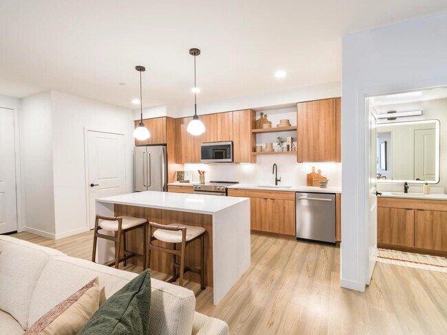 Los elegantes gabinetes y los cálidos tonos de madera aportan equilibrio y estilo a todas las cocinas de Modera Higley Commons. - Modera Higley Commons