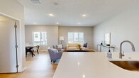 Located on Garland Ave in Norwalk, Iowa, this well-designed three-story home offers 2 bedrooms and 3 bathrooms across a thoughtfully laid-out floor plan. The ground level houses a spacious garage with an automatic opener, concrete flooring, and brick accent walls, providing secure and convenient parking.

The main living floor is the heart of the home, featuring an open-concept kitchen and living room. The kitchen is outfitted with white shaker cabinets, quartz countertops, stainless steel appliances, and a large peninsula with bar seating — ideal for casual dining or entertaining. Light hardwood flooring flows throughout, complementing the neutral palette. The living area is bright and airy, with large windows that invite natural light and offer views of the surrounding neighborhood.

The upper floor is dedicated to the two bedrooms and additional bathrooms. The primary bedroom is generously sized, featuring plush carpeting, a ceiling fan, a closet with sliding doors, and windows with outdoor views. The en-suite bathroom includes white cabinetry and a dedicated closet space. The second bedroom is equally comfortable with carpet flooring and ample natural light. A clean, neutral half-bath is also found on the main level. Throughout, the home maintains a cohesive modern aesthetic with soft tones and light wood flooring.
