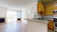 Located in the Palms neighborhood of Los Angeles, this single-floor residence on Castle Heights Avenue offers a well-designed layout with bright, open living spaces. Light wood flooring runs throughout, complementing the neutral, warm-toned walls that create a clean and welcoming ambiance.

The kitchen is thoughtfully equipped with warm honey-toned cabinetry, granite-style countertops, a stainless steel gas range with overhead ventilation, and a breakfast bar that opens to the dining and living areas. A ceiling fan overhead enhances comfort in the adjacent dining space. The living room features a brick fireplace as a notable focal point.

The bedrooms stand out with vaulted ceilings and distinctive arched windows that flood the rooms with natural light. One bedroom includes a built-in closet with sliding doors and dual arched windows, while the other offers a similarly airy feel. Both bathrooms are finished with light wood flooring; one features a large vanity with extended countertop and mirrored medicine cabinet, while the other includes a tub-shower combination with sliding glass doors beneath a vaulted ceiling. A sliding glass door in the living area leads to an outdoor balcony, further enhancing the connection to natural light and the surrounding environment.