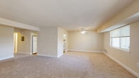 Located at 1813 Rambling Ridge Ln in Baltimore, MD, this single-floor, 2-bedroom, 1-bathroom home offers a thoughtfully arranged layout with a welcoming flow throughout. The expansive living room is a standout feature, finished with plush wall-to-wall carpeting, neutral warm-toned walls, a textured ceiling, and a ceiling fan with light fixture. A window allows natural light to fill the space, while an open sightline connects to the kitchen, enhancing the sense of openness. The kitchen features white cabinetry extending to the ceiling for ample storage, granite-look countertops, a stainless steel sink, and hardwood-style flooring, giving it a clean and functional character. Both bedrooms are carpeted and bathed in natural light from multiple windows. The spacious primary bedroom includes a full-width louvered double closet and direct access to an adjacent room. The second bedroom is well-proportioned with a closet and natural views to the outdoors. The bathroom is clean and bright, featuring a full tub-shower combination with white tile surround. A dedicated laundry area and hallway complete the practical layout of this comfortable Baltimore home.