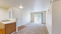 Located at 618 N Second St in Dixon, CA, this 2-bedroom, 1-bathroom unit offers a practical and comfortable layout on a single floor. The open-concept main area combines the living room, dining room, and kitchen into one connected space. The living room features neutral carpet, a ceiling fan, and a sliding glass door that opens to a private balcony, allowing natural light to fill the room. The kitchen is equipped with warm wood-toned cabinetry, a white refrigerator, electric range, overhead ventilation, and a countertop sink with additional cabinet storage. A half-wall partition separates the kitchen from the living and dining areas, adding definition without closing off the space. Both bedrooms are carpeted and bright, with large windows that bring in natural light and views of the surrounding neighborhood. The primary bedroom offers generous proportions and access to a spacious closet with full-length hanging rods. A hallway connects the bedrooms to the full bathroom, which features a wood-toned vanity with under-sink storage, a well-lit mirror, and hard-surface flooring. Three closets throughout the unit provide ample storage. The overall aesthetic is clean and neutral, creating a move-in-ready environment.