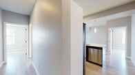 Located at 70 Park East Dr in Winnipeg, this modern 3-bedroom, 1-bathroom unit offers a well-designed layout with contemporary finishes throughout. Light-toned laminate flooring runs seamlessly across the space, complementing the clean, neutral palette of the walls and trim.

The kitchen is a standout feature, boasting a two-tone cabinetry design with white upper cabinets and dark lower cabinets, a light-coloured countertop, a grey subway tile backsplash, and a full suite of stainless steel appliances including a refrigerator, range, and built-in microwave. A peninsula with a striking blue accent panel and an undermount sink adds a bold, modern touch and provides additional workspace.

The open living room is bathed in natural light from a large window and flows effortlessly from the kitchen, creating a cohesive and spacious common area. The hallways connect the rooms efficiently, maintaining a clean and functional layout.

The primary bedroom features a rustic barn-style sliding door with frosted glass panels, a built-in closet, and a window offering urban views. Additional bedrooms are bright and versatile. The bathroom includes a full soaker tub with a clean white surround. Two connecting hallways provide smooth circulation throughout the unit.