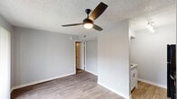 Located at 7760 McCallum Blvd in Dallas, TX, this one-bedroom, one-bathroom unit offers a thoughtfully arranged floor plan that maximizes every inch of its compact footprint. The open-concept main living area seamlessly combines the living room, dining room, and kitchen into a single, flowing space. Wood-look flooring runs throughout the main areas, lending a clean and modern aesthetic, while a ceiling fan overhead provides both style and function. A sliding glass door fitted with vertical blinds opens to a private balcony, allowing natural light to filter in and offering an outdoor retreat. The kitchen features cabinetry with ample storage, complementing the efficient layout. The bedroom is carpeted for added comfort and includes a ceiling fan, a closet, and a window with blinds that brings in natural light. Two closets throughout the unit provide generous storage options. The bathroom is well-appointed with a tiled shower-tub combination, a vanity with storage, and wood-look flooring that ties the space together. Textured ceilings are present throughout, adding a classic touch to the interior. This unit delivers a practical and comfortable living environment in a well-situated Dallas location.