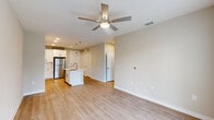 Located at 4103 Rogers Road in San Antonio, TX, this one-bedroom, one-bathroom residence offers a thoughtfully designed layout across a single floor. The open-concept living and kitchen area serves as the heart of the home, featuring light wood-style luxury vinyl flooring that flows seamlessly throughout. A ceiling fan anchors the living space, which is bathed in natural light and provides direct access to the outdoors through French doors overlooking a lush, landscaped green area. The kitchen is outfitted with crisp white shaker cabinets, a herringbone tile backsplash, white quartz countertops, stainless steel appliances including a refrigerator, range, and microwave, and a center island with a sink — ideal for both cooking and casual dining. The bedroom is a comfortable, well-lit retreat with a ceiling fan and a window offering views of the surrounding community. Two closets provide generous storage, including a walk-in closet with built-in shelving and hanging rods. The bathroom features a white vanity with quartz countertops, wood-style flooring, and a full soaking tub with a tiled surround. Additional conveniences include a dedicated laundry area and utility room, completing this well-appointed home.