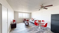 Located at 373 NW 5th St in the heart of downtown Oklahoma City, this efficiently designed single-floor unit makes excellent use of its compact footprint. The open-plan living, dining, and kitchen area forms the core of the space, bathed in natural light through large sliding windows that frame impressive elevated views of the Oklahoma City skyline and surrounding cityscape. Durable hardwood-style flooring runs throughout, complementing the neutral gray-and-white color palette. A ceiling fan overhead adds both function and a casual finishing touch to the living area.

The kitchen is thoughtfully appointed with crisp white cabinetry, light quartz countertops, a stainless steel undermount sink with a modern pull-down faucet, and a classic white subway tile backsplash — a clean, contemporary aesthetic with ample cabinet storage.

The unit features two bathrooms, one of which includes a full tub-and-shower combination with white tile flooring and a single-vanity setup. A dedicated vanity nook in the hallway area provides additional grooming space, complete with built-in drawers, a wall-mounted mirror, and vanity lighting. Three closets offer generous storage throughout. The textured ceilings are consistent across the space, and the well-connected hallway layout ensures smooth flow between all areas.