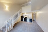 Located at 2486 Green Pine Dr in Burton, Michigan, this two-story residence offers a well-organized layout across two levels. The main floor serves as the primary living area, featuring a carpeted living room with a front entry door and a large window that brings in natural light. A white-railed staircase is a central architectural feature, leading to the upper level. The kitchen, which flows into the dining area, is equipped with black appliances including a refrigerator, stove, and dishwasher, complemented by white cabinetry, a granite-style countertop, and a sink. An open shelving pantry area is conveniently accessible adjacent to the kitchen. Baseboard heating units are present throughout the main floor, ensuring year-round comfort. Upstairs, the spacious bedroom features plush carpet, a ceiling fan with light fixture, and a closet with bi-fold doors offering ample storage. The upper level also includes a window providing natural light and an open loft-style overlook. The full bathroom is finished with tile flooring, a tub/shower combo with a white surround, and clean white fixtures. This residence offers a practical and comfortable layout suited for everyday living.