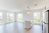 Located at 3600 East-West Hwy in Hyattsville, MD, this thoughtfully designed 2-bedroom, 2-bathroom residence offers a bright and contemporary living experience. The open-concept kitchen and living area serves as the heart of the home, featuring light wood-tone flooring throughout, recessed lighting, and stylish globe pendant fixtures. Large windows line the living space, flooding the interior with natural light and offering elevated views of the surrounding neighborhood.

The kitchen is well-appointed with white shaker cabinetry extending to the ceiling, a herringbone tile backsplash, white quartz countertops, a central island, and a full suite of stainless steel appliances including a range, microwave, dishwasher, and refrigerator.

Both bedrooms are generously sized with large windows and clean white walls. The spacious primary bedroom features dual windows with expansive outdoor views. The residence includes five closets, one of which is a sizable walk-in with wire shelving.

The bathrooms are finished with marble-look tile flooring and white subway tile surrounds in the tub-shower combinations, lending a crisp, clean aesthetic. A welcoming entrance and well-connected hallway layout complete this move-in-ready home.
