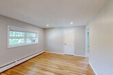 Located at 60 Goldthwaite Rd in Worcester, MA, this well-appointed 2-bedroom, 1-bathroom single-floor home offers a clean, modern aesthetic throughout. Warm-toned hardwood floors run continuously through the living areas and bedrooms, complemented by neutral gray walls and crisp white trim that create a bright, cohesive interior.

The kitchen is thoughtfully designed with gray shaker-style cabinetry, white quartz countertops, a gray subway tile backsplash, a stainless steel dishwasher, and a deep sink positioned beneath a window that lets in natural light. The living room provides a comfortable, open area with recessed lighting and baseboard heating.

The spacious primary bedroom features recessed lighting, a large window with views of surrounding greenery, and hardwood floors. The second bedroom is equally well-lit, benefiting from two windows and baseboard heating. Both bedrooms offer a bright and airy feel. A closet with built-in shelving adds practical storage to one of the bedrooms.

The full bathroom is finished with gray subway tile, a modern vanity with a white countertop, and a window providing natural light and ventilation. Baseboard heating is present throughout the home, ensuring year-round comfort. The layout is efficiently connected via a central hallway, making the space feel functional and easy to navigate.
