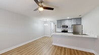 Located at 101 Cypress Plantation Rd in Moncks Corner, South Carolina, this efficiently designed one-bedroom, one-bathroom residence offers a thoughtfully laid-out single-floor plan with modern finishes throughout. Light wood-look flooring flows continuously across every room, creating a cohesive and clean aesthetic.

The open-concept kitchen and living area serves as the heart of the home. The kitchen is outfitted with gray shaker-style cabinetry, stainless steel appliances including a range, over-the-range microwave, and refrigerator, as well as a striking marble-look quartz peninsula with an integrated sink. A white subway tile backsplash adds a classic touch. A pendant chandelier over the dining area and a ceiling fan in the living space provide both style and functionality. Natural light enters through a window near the front entry door.

The spacious primary bedroom is a comfortable retreat, featuring a ceiling fan, a dedicated closet with panel doors, and neutral gray walls that lend a calm, airy feel.

The bathroom is cleanly finished with a tub-shower combination accented by white mosaic tile, a gray vanity with a white countertop, brushed gold fixtures, and matching light wood-look flooring. Every detail reflects a commitment to a fresh, modern living experience.