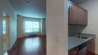 This fourth-floor apartment at 305 E Mill Plain Blvd in Vancouver, Washington offers a well-designed single-level layout that balances functionality with modern finishes throughout. The open living area is anchored by rich, dark hardwood flooring that extends across the main living space, complemented by neutral walls and a window fitted with blinds that allows natural light to fill the room. A wall-mounted HVAC unit provides climate control convenience.

The galley-style kitchen is efficiently laid out with dark wood cabinetry, granite countertops, a stainless sink, and a full suite of appliances including a refrigerator, electric range, built-in microwave, and dishwasher. The kitchen flows seamlessly into the main living area, creating a cohesive open feel.

A dedicated in-unit laundry area with a stacked washer and dryer adds everyday practicality. The bedroom features plush carpeting, a tray ceiling detail that adds architectural interest, and a window that brings in natural light.

The bathroom is finished with tile flooring, a granite-topped vanity with wood cabinetry, a full soaking tub, and tile-surround walls, offering a clean and comfortable space. Overall, the unit presents a contemporary and functional living environment in a convenient Vancouver location.