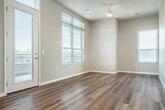 This well-appointed 2-bedroom, 2-bathroom single-floor residence offers a thoughtfully designed open-concept layout that seamlessly connects the kitchen and living room, creating an inviting and functional living space. The kitchen is a standout feature, showcasing crisp white cabinetry with modern hardware, a subway tile backsplash, quartz countertops, and a full suite of stainless steel appliances including a refrigerator, dishwasher, and range. A central island with a bold white surface and matte black pendant lighting overhead adds both style and practicality. Wood-style flooring flows consistently throughout the home, complementing the neutral wall tones and clean white trim. The living area is bright and open, benefiting from multiple windows and access to a private patio. The primary bedroom is generously sized, offering peaceful views of lush greenery through large picture windows that flood the room with natural light. Four closets—including walk-in closets with wire shelving systems—provide ample storage throughout the unit. Both bathrooms feature clean, modern finishes with wood-look flooring. A dedicated laundry area adds everyday convenience, rounding out this well-equipped and move-in-ready residence.