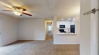 This 880 square foot apartment offers a practical and comfortable living space. The layout includes two bedrooms, two full bathrooms, a combined kitchen and living area, and a dedicated laundry room. The primary bedroom, measuring 170 square feet, provides ample space for rest and relaxation.

The living areas feature neutral-toned walls and plush carpeting, creating a warm and inviting atmosphere. Ceiling fans with integrated lighting fixtures are installed in the main rooms, enhancing air circulation and ambiance. Large windows and sliding glass doors leading to a balcony allow natural light to flood the space, offering pleasant outdoor views.

The kitchen is equipped with modern appliances, including a built-in microwave and full-sized refrigerator. White cabinetry and light-colored countertops contribute to a clean, contemporary aesthetic. The in-unit laundry room comes furnished with a washer and dryer set for added convenience.

Both bathrooms showcase a clean, white design with tiled flooring and bathtub-shower combinations. The apartment also features two closets with wire shelving, providing ample storage solutions.

Overall, this apartment combines functionality with comfort, offering a well-designed living space suitable for various lifestyle needs.
