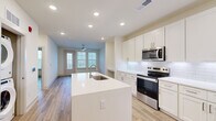 This well-designed one-bedroom, two-bathroom residence at 190 Moll Rd offers a thoughtfully organized single-floor layout that maximizes every square foot of its compact footprint. The open-concept kitchen and living area serves as the heart of the home, featuring crisp white shaker cabinetry, a classic subway tile backsplash, stainless steel appliances including an electric range and built-in microwave, and a large center island with a undermount sink — ideal for both meal preparation and casual dining. Recessed lighting throughout keeps the space bright and modern.

The living area flows naturally from the kitchen and opens to a private balcony through a glass door flanked by windows, filling the room with natural light and outdoor views. A ceiling fan adds comfort and a finishing touch. Light wood-tone luxury vinyl plank flooring runs consistently throughout the home, creating a cohesive, warm aesthetic.

The bedroom is generously proportioned, featuring a ceiling fan, double windows with views of the surrounding landscape, and ample wall space. A convenient built-in desk nook with cabinetry provides a dedicated workspace or study area. The two bathrooms are finished in neutral tones, with one featuring a glass-enclosed walk-in shower, white shaker vanity cabinetry, and light tile flooring — delivering a clean, contemporary feel throughout.