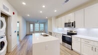 This well-designed one-bedroom, two-bathroom residence at 190 Moll Rd offers a thoughtfully organized single-floor layout that maximizes every square foot of its compact footprint. The open-concept kitchen and living area serves as the heart of the home, featuring crisp white shaker cabinetry, a classic subway tile backsplash, stainless steel appliances including an electric range and built-in microwave, and a large center island with a undermount sink — ideal for both meal preparation and casual dining. Recessed lighting throughout keeps the space bright and modern.

The living area flows naturally from the kitchen and opens to a private balcony through a glass door flanked by windows, filling the room with natural light and outdoor views. A ceiling fan adds comfort and a finishing touch. Light wood-tone luxury vinyl plank flooring runs consistently throughout the home, creating a cohesive, warm aesthetic.

The bedroom is generously proportioned, featuring a ceiling fan, double windows with views of the surrounding landscape, and ample wall space. A convenient built-in desk nook with cabinetry provides a dedicated workspace or study area. The two bathrooms are finished in neutral tones, with one featuring a glass-enclosed walk-in shower, white shaker vanity cabinetry, and light tile flooring — delivering a clean, contemporary feel throughout.