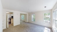 Located at 1 Avalon Way in Shrewsbury, Massachusetts, this two-floor residence offers a thoughtfully designed layout filled with natural light throughout. The open living areas feature neutral-toned carpeting and crisp white walls, creating a clean and airy atmosphere. Multiple windows on both levels frame lush, tree-lined views, flooding the interior with sunlight and providing a strong connection to the surrounding greenery.

The kitchen is well-equipped with white cabinetry, dark countertops, hardwood-style flooring, and black appliances including a gas range, dishwasher, and built-in microwave. A window above the sink adds natural light to the workspace. The upper level showcases a spacious bedroom with vaulted ceilings, a large picture window, and access to a walk-in closet, enhancing the sense of openness and storage.

Bathrooms are finished with white vanities, hardwood-style flooring, and tiled shower surrounds, offering a clean, functional aesthetic. A dedicated in-unit laundry area accommodates a full-size washer and dryer with additional wire shelving for storage. Throughout the residence, the consistent use of light tones, plush carpeting in living spaces, and durable flooring in wet areas contribute to a cohesive and comfortable living environment.