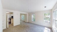 Located at 1 Avalon Way in Shrewsbury, Massachusetts, this two-floor residence offers a thoughtfully designed layout filled with natural light throughout. The open living areas feature neutral-toned carpeting and crisp white walls, creating a clean and airy atmosphere. Multiple windows on both levels frame lush, tree-lined views, flooding the interior with sunlight and providing a strong connection to the surrounding greenery.

The kitchen is well-equipped with white cabinetry, dark countertops, hardwood-style flooring, and black appliances including a gas range, dishwasher, and built-in microwave. A window above the sink adds natural light to the workspace. The upper level showcases a spacious bedroom with vaulted ceilings, a large picture window, and access to a walk-in closet, enhancing the sense of openness and storage.

Bathrooms are finished with white vanities, hardwood-style flooring, and tiled shower surrounds, offering a clean, functional aesthetic. A dedicated in-unit laundry area accommodates a full-size washer and dryer with additional wire shelving for storage. Throughout the residence, the consistent use of light tones, plush carpeting in living spaces, and durable flooring in wet areas contribute to a cohesive and comfortable living environment.