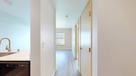 Located at 19501 40th Ave W in Lynnwood, WA, this one-bedroom, one-bathroom unit offers a thoughtfully designed single-floor layout that makes efficient use of its compact footprint. The living area features light-toned laminate hardwood flooring and neutral wall tones, creating a bright and clean atmosphere with an open connection to the kitchen. The kitchen is well-appointed with light wood cabinetry, white countertops, black appliances including a full-size refrigerator and range, and a stainless steel sink — providing all the essentials in a functional U-shaped configuration. The bedroom is carpeted for comfort, features a large window with views of the surrounding building exterior, a baseboard heater, and includes a built-in closet with double bifold doors. The bedroom connects conveniently to the full bathroom, which is finished with a clean, all-white tub and shower surround equipped with an accessibility grab bar and wood-toned flooring. Throughout the unit, warm wood-trimmed door frames, soft neutral walls, and consistent flooring choices lend a cohesive and understated aesthetic. This unit offers a straightforward, livable layout well-suited for individuals or couples seeking a low-maintenance residence in Lynnwood.