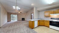 Located at 2722 Rainbow Ave in Bloomington, IL, this single-floor, 2-bedroom, 2-bathroom home offers a well-designed layout with a practical and comfortable living experience. The open-concept living and dining area flows seamlessly into the kitchen, creating a spacious, connected feel. The living room features vaulted ceilings, a ceiling fan, a marble-surround fireplace, and sliding glass doors that open onto a private patio, filling the space with natural light and outdoor views. The kitchen is equipped with warm oak cabinetry, granite-look countertops, a peninsula with a built-in dishwasher, a double-basin sink, and a full suite of appliances including an electric range and refrigerator. Both bedrooms are carpeted and include ceiling fans and vaulted ceilings, with the primary bedroom offering generous proportions and large closet space. Four closets throughout the home provide abundant storage, including a spacious walk-in with wire shelving systems. The two bathrooms feature oak vanities with granite-look countertops and tiled flooring. A dedicated laundry area adds further convenience. The home's consistent use of neutral tones, carpet, and warm wood trim gives it a cohesive and inviting ambiance throughout.