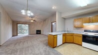 Located at 2722 Rainbow Ave in Bloomington, IL, this single-floor, 2-bedroom, 2-bathroom home offers a well-designed layout with a practical and comfortable living experience. The open-concept living and dining area flows seamlessly into the kitchen, creating a spacious, connected feel. The living room features vaulted ceilings, a ceiling fan, a marble-surround fireplace, and sliding glass doors that open onto a private patio, filling the space with natural light and outdoor views. The kitchen is equipped with warm oak cabinetry, granite-look countertops, a peninsula with a built-in dishwasher, a double-basin sink, and a full suite of appliances including an electric range and refrigerator. Both bedrooms are carpeted and include ceiling fans and vaulted ceilings, with the primary bedroom offering generous proportions and large closet space. Four closets throughout the home provide abundant storage, including a spacious walk-in with wire shelving systems. The two bathrooms feature oak vanities with granite-look countertops and tiled flooring. A dedicated laundry area adds further convenience. The home's consistent use of neutral tones, carpet, and warm wood trim gives it a cohesive and inviting ambiance throughout.
