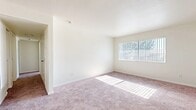Located in Barstow, CA, this single-story, 3-bedroom, 2-bathroom home offers a practical and comfortable layout designed for everyday living. The bedrooms are carpeted in a warm, neutral tone and filled with natural light from large windows dressed with vertical blinds. The spacious primary bedroom provides a generous footprint and easy access to one of the two full bathrooms. The kitchen is thoughtfully designed with white cabinetry, light countertops, a double-basin sink, a gas range, and a dishwasher, all set atop wood-look flooring that extends through the kitchen and bathrooms. One bathroom features a wide vanity with white cabinetry and a large mirror, a tub-shower combination, and a frosted window for natural light and privacy. The second bathroom includes a single-sink vanity and direct access to a closet with built-in shelving, adding convenient storage. A central hallway connects the rooms efficiently throughout the home. Neutral wall tones and clean white trim are consistent throughout, lending a bright, cohesive feel to the entire space. This home offers a straightforward, move-in-ready layout suited for a range of living needs.