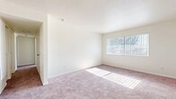Located in Barstow, CA, this single-story, 3-bedroom, 2-bathroom home offers a practical and comfortable layout designed for everyday living. The bedrooms are carpeted in a warm, neutral tone and filled with natural light from large windows dressed with vertical blinds. The spacious primary bedroom provides a generous footprint and easy access to one of the two full bathrooms. The kitchen is thoughtfully designed with white cabinetry, light countertops, a double-basin sink, a gas range, and a dishwasher, all set atop wood-look flooring that extends through the kitchen and bathrooms. One bathroom features a wide vanity with white cabinetry and a large mirror, a tub-shower combination, and a frosted window for natural light and privacy. The second bathroom includes a single-sink vanity and direct access to a closet with built-in shelving, adding convenient storage. A central hallway connects the rooms efficiently throughout the home. Neutral wall tones and clean white trim are consistent throughout, lending a bright, cohesive feel to the entire space. This home offers a straightforward, move-in-ready layout suited for a range of living needs.