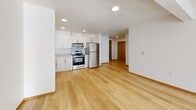 Located at 2955 NE 11th St in Renton, Washington, this single-floor residence offers four bedrooms and one bathroom across a generously sized floor plan. The open-concept kitchen and living area serves as the heart of the home, featuring light hardwood flooring, recessed lighting, white cabinetry, and a full suite of stainless steel appliances including a refrigerator, range, microwave, and dishwasher. The seamless layout allows the kitchen to flow naturally into the living space, creating an expansive and airy atmosphere. Bedrooms are a mix of hardwood and carpeted flooring, with several rooms featuring large windows that invite abundant natural light and views of the surrounding neighborhood. The primary bedroom is a comfortable, well-proportioned space. The full bathroom is clean and functional, outfitted with a vanity, large mirror, and a bathtub with shower. Practical features include two dedicated laundry areas with in-unit washer and dryer, three closets providing ample storage, and a private balcony. Warm wood-toned doors and trim add a consistent design detail throughout the hallways and rooms. The overall aesthetic is bright, modern, and move-in ready.