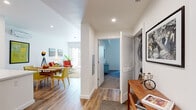 This single-story residence in El Cerrito, California offers a thoughtfully designed open-concept layout that seamlessly connects its key living spaces. The interior is defined by crisp white walls, recessed lighting, and warm wood-tone flooring that flows consistently throughout the main areas, creating a cohesive and inviting atmosphere.

The central hallway serves as the home's spine, providing access to each functional zone. To one side, the living and dining areas occupy a bright, open space enhanced by natural light from large windows. The living room features a wall-mounted mini-split system for climate control, while the adjacent dining area offers ample room for a full table setting.

The kitchen is outfitted with floor-to-ceiling flat-front cabinetry in a light gray finish, white quartz countertops, a subway tile backsplash, and a full suite of stainless steel appliances including a gas range, dishwasher, and microwave.

The bedroom is a calm retreat with carpeted flooring, a wall-mounted mini-split unit, and a large window framing views of the surrounding landscape. The bathroom features light wood-tone tile flooring, warm taupe cabinetry, a wide vanity with an integrated sink, and a large mirror. A louvered closet door and in-unit stacked laundry are also conveniently located along the hallway.