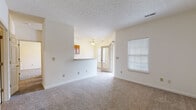 Located at 97 Arbor Pl in New Albany, Indiana, this single-story home offers a practical and well-organized floor plan designed for comfortable everyday living. The open living area is carpeted throughout and features neutral cream-toned walls, a textured ceiling, and a ceiling fan, creating a bright and airy atmosphere. A pass-through countertop seamlessly connects the living space to the kitchen, enhancing the open feel. Natural light filters in through multiple windows fitted with blinds, contributing to the home's welcoming ambiance. The kitchen is equipped with warm oak cabinetry, light countertops, and black appliances including a refrigerator and range, with light wood-style flooring underfoot. A hallway leads from the kitchen toward the bathroom and additional rooms, maintaining a smooth flow throughout the home. The bedrooms are generously sized, each carpeted and equipped with ceiling fans and windows that bring in natural light. The bathroom features wood-toned cabinetry and light wood-style flooring. A dedicated laundry room provides added convenience, complete with washer/dryer hookups, shelving, and an in-unit HVAC system. The exterior features a concrete driveway and an attached garage, rounding out this functional and move-in ready home.