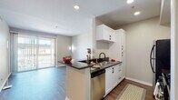 Located at 9710 Zelzah Ave in the Northridge neighborhood of Los Angeles, this single-floor residence offers a thoughtfully designed, open-concept layout that balances functionality with modern style. The kitchen serves as a central hub of the home, featuring a peninsula with dark granite-style countertops, crisp white cabinetry with matte black hardware, a stainless steel double sink, dishwasher, gas range, and a full-size refrigerator. The galley-style configuration provides generous storage and counter space, making it ideal for everyday cooking. The kitchen flows seamlessly into the living area, which is finished with durable hardwood-style flooring and benefits from abundant natural light through a sliding glass door that opens to a private balcony. A ceiling fan adds comfort to the living space. The bedrooms are carpeted for warmth and comfort, each featuring arched windows that invite natural light and offer views of the surrounding neighborhood. The bathrooms are clean and functional, each equipped with a glass-enclosed shower-tub combination and hardwood-style flooring. Neutral wall tones throughout the residence create a calm, cohesive atmosphere, making the space easy to personalize.