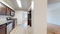 Located at 1000 US Highway 1 in Edison, NJ, this well-appointed one-bedroom, one-bathroom residence offers a thoughtfully designed single-floor layout across a comfortable living footprint. Gleaming hardwood floors flow throughout the main living areas, lending warmth and continuity to the space.

The living room is bright and airy, benefiting from large windows and a glass sliding door that invite generous natural light and offer outdoor views. The adjacent dining area provides a seamless transition into the kitchen, which is well-equipped with rich dark-wood cabinetry, granite countertops, a tile backsplash, and a full suite of stainless steel appliances including a gas range, dishwasher, built-in microwave, and refrigerator.

The spacious bedroom features polished hardwood flooring, a large window framing green tree views, and access to a generously sized walk-in closet complete with built-in shelving rods. The full bathroom is finished with large-format tile flooring, a granite-topped dark wood vanity, and a tub-shower combination enclosed by sliding glass doors. A hallway connects the key areas efficiently, completing this clean and functional layout.