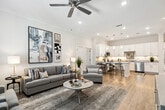 This contemporary 920 square foot apartment at Alluvia 2 offers a thoughtfully designed single-floor living space. The heart of the home is an open-concept kitchen and living area, featuring a pristine white kitchen with sleek cabinetry, stainless steel appliances, and a functional island with seating. The living room seamlessly connects, boasting ample natural light and stylish decor.

The spacious 210 square foot primary bedroom provides a serene retreat, complete with plush carpeting and artistic wall accents. The bathroom showcases a modern vanity, large mirror, and a glass-enclosed shower. Convenience is key with an in-unit laundry room equipped with full-sized appliances.

Throughout the apartment, neutral tones and light wood flooring create a cohesive, airy ambiance. Strategic lighting, including pendant fixtures and recessed lights, enhances the space. The decor features a mix of contemporary and classic elements, with carefully curated artwork adorning the walls.

Storage solutions are integrated seamlessly, with built-in closets and cabinetry maximizing the available space. The overall design prioritizes functionality without compromising on style, making efficient use of every square foot in this compact yet luxurious urban dwelling.