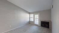 Located at 201 Parkland Hills Dr in Fairfield, Ohio, this single-floor residence offers a thoughtfully laid-out interior with a neutral color palette and a blend of carpet and wood-look flooring throughout. The living area is a standout space, highlighted by soaring vaulted ceilings that create an open, airy atmosphere, soft carpeting underfoot, and a tile-surround fireplace that serves as a warm focal point. A sliding glass door and adjacent window flood the room with natural light while providing access to the outdoors. The entry foyer is finished with wood-look flooring and recessed lighting, creating a welcoming transition into the main living space. The kitchen features dark gray cabinetry, light countertops, a classic white subway tile backsplash, black appliances including a refrigerator and range, and wood-look flooring — offering both style and functionality in a well-organized galley layout. The bedrooms are generously sized, each with plush carpeting and windows that bring in natural light and views of the surrounding neighborhood. A full bathroom is conveniently accessible from the bedroom area, complete with a tub/shower combination and wood-look flooring. This well-appointed single-story home combines practical design with comfortable living spaces throughout.